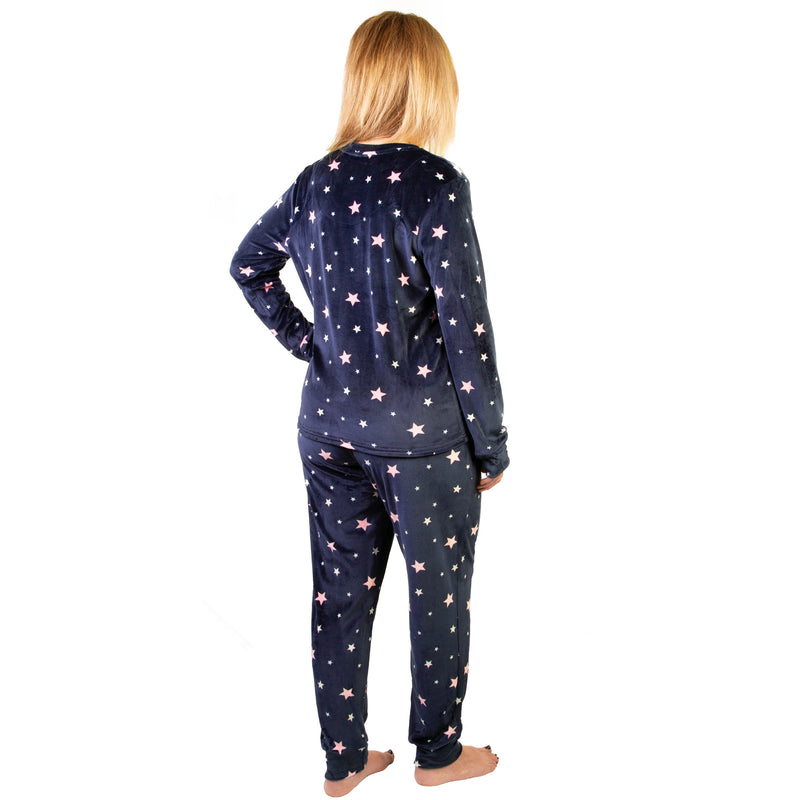 Person wearing navy blue pajamas with star pattern on a white background