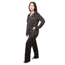 Woman wearing a black pajama set with white polka dots on a white background